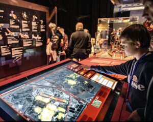 Garçon qui teste les écrans de contrôle de l’exposition espions